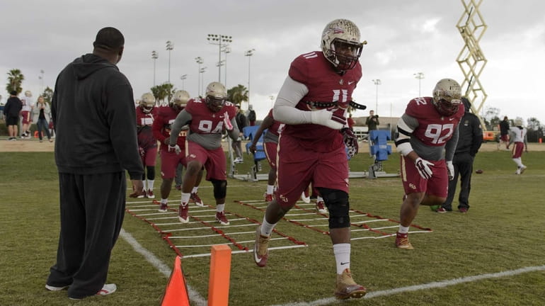 Florida State defensive tackle Derrick Mitchell, center, and Justin Shanks,...