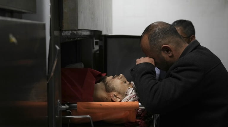 A Palestinian killed in a settler rampage lies in the...