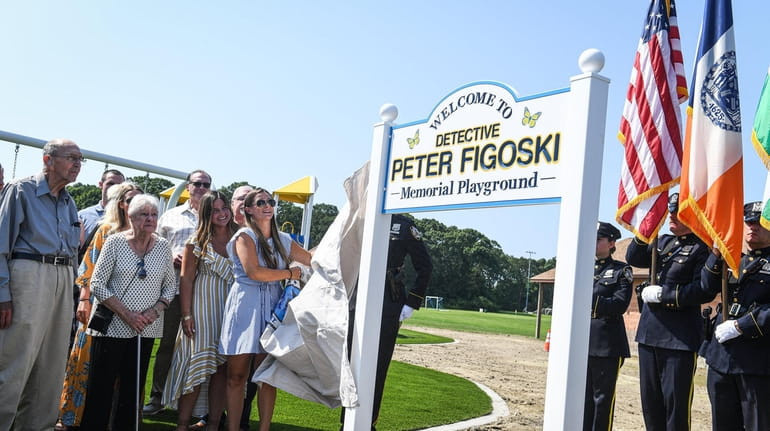 Caroline Figoski unveils the sign for the playground named for...
