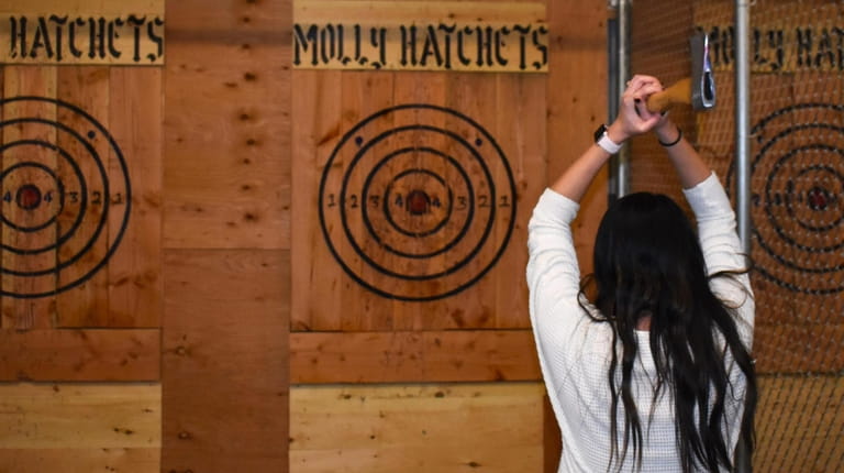 Kirstin Montgomery, of Centereach, tries at ax throwing at Molly Hatchets...