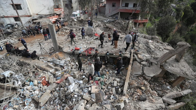 People gather on the rubble of a paramedic center that...
