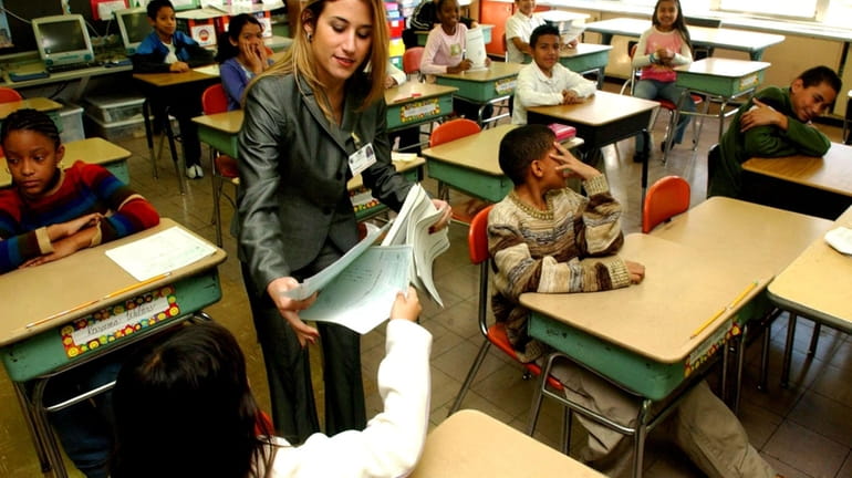 A teacher collects exams at Laurel Park Elementary School in...