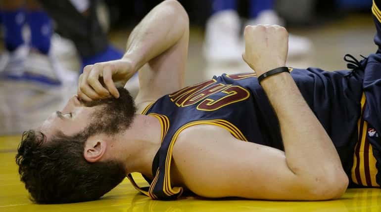 Cleveland Cavaliers forward Kevin Love remains on the floor after...
