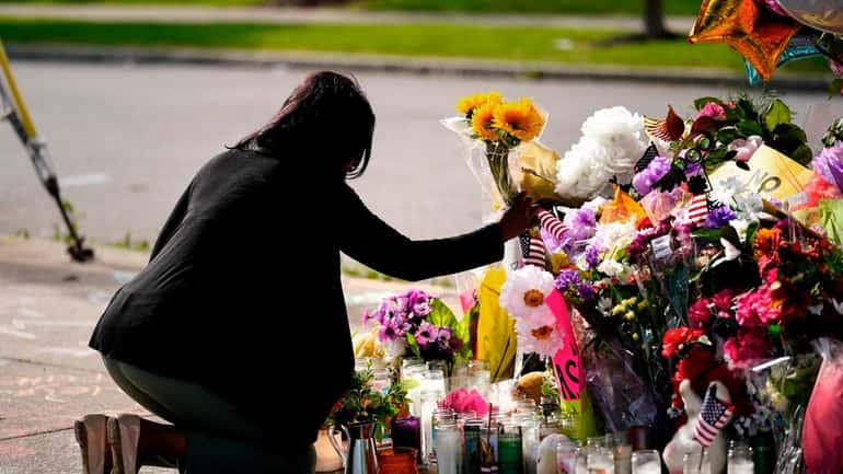 A woman pays her respects at the scene of Saturday's...
