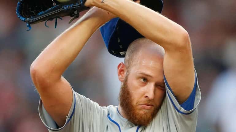 Mets starting pitcher Zack Wheeler (45) wipes his face between...