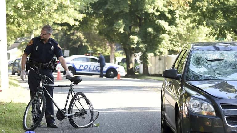 Police investigate the scene where a bicyclist was seriously injured after...