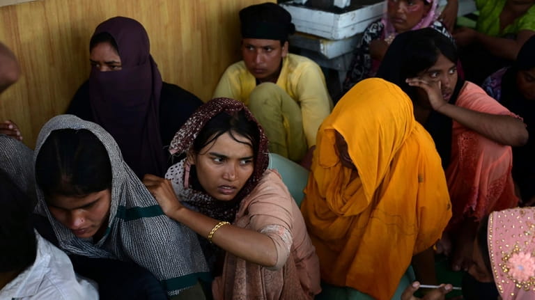 Rohingya refugees rescued from a capsized boat rest at a...