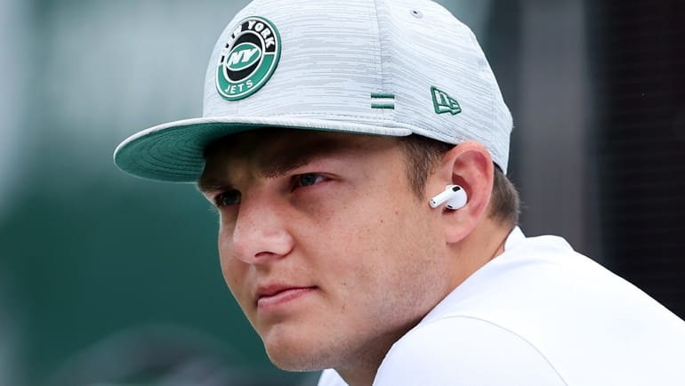 Injured Jets quarterback Zach Wilson watches warm-ups from the bench before...
