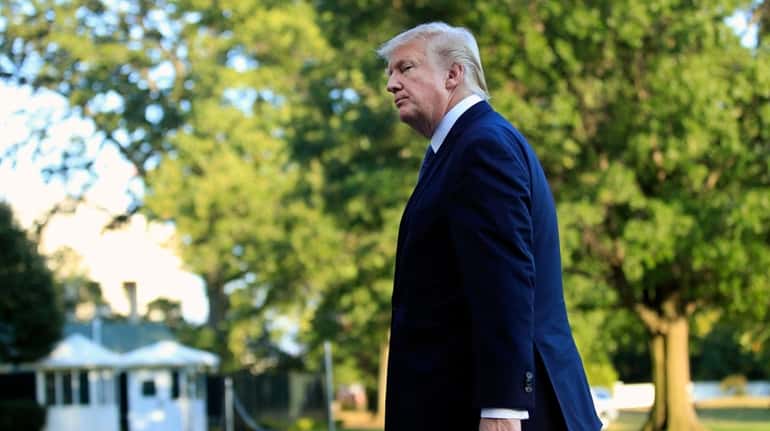President Donald Trump walks towards the White House in Washington,...