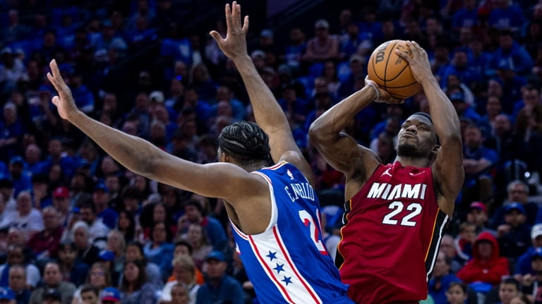 Miami Heat's Jimmy Butler, right, shoots as he is fouled...