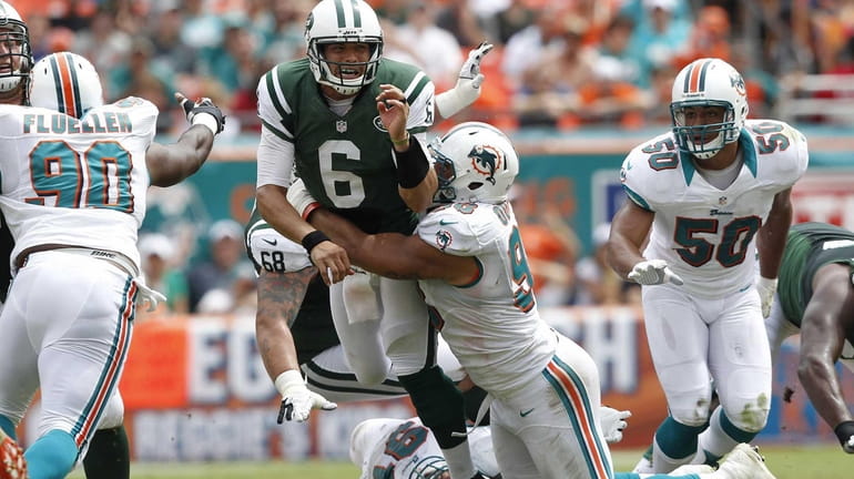 Jared Odrick of the Miami Dolphins hits Jets quarterback Mark...