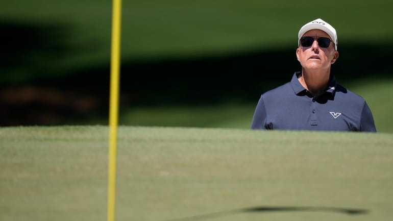 Phil Mickelson watches his bunker shot on the seventh hole...