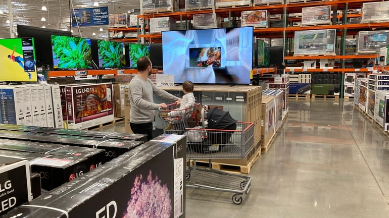 Big-screen televisions on display in the electronics section of a...