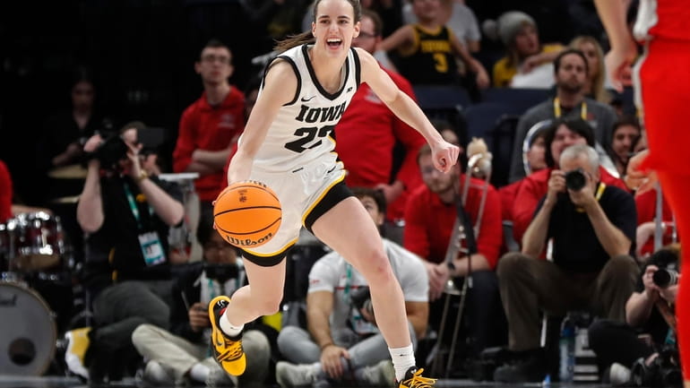FILE - Iowa guard Caitlin Clark smiles after catching her...