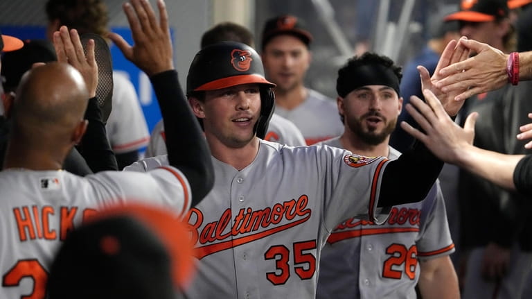 Baltimore Orioles' Adley Rutschman is congratulated by teammates in the...