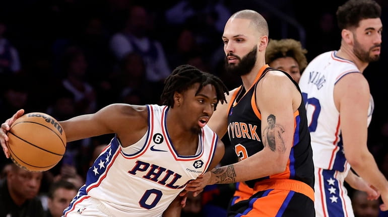 Evan Fournier #13 of the Knicks defends against Tyrese Maxey #0...