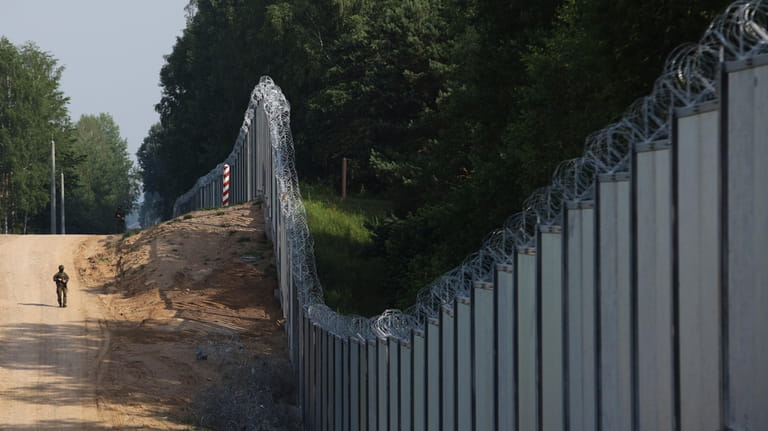 A Polish border guard patrols the area of a built...