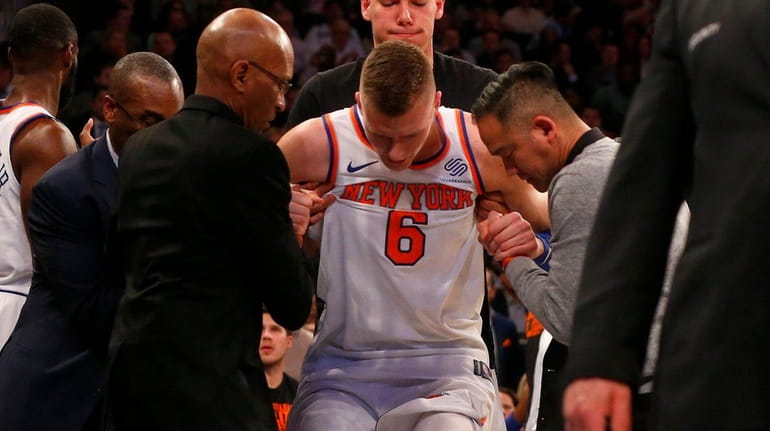 Kristaps Porzingis of the Knicks is helped off the court...