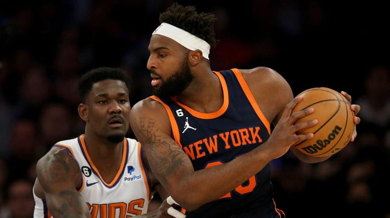 Knicks center Mitchell Robinson controls the ball against Suns center Deandre...
