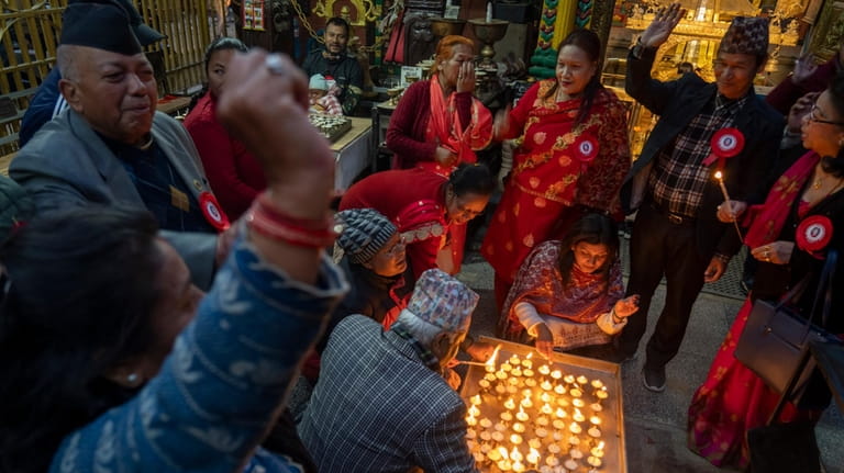 Supporters light candles and chant slogans hailing former king Gyanendra...