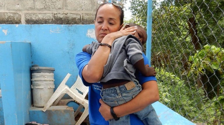 Melissa Correa Borger holds a young child in Haiti. "People go there...