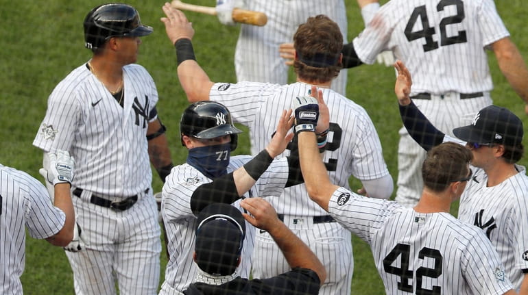 Clint Frazier of the Yankees celebrates with his teammates after scoring...