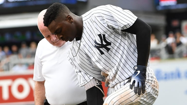 Yankees trainer Steve Donohue checks on shortstop Didi Gregorius after...