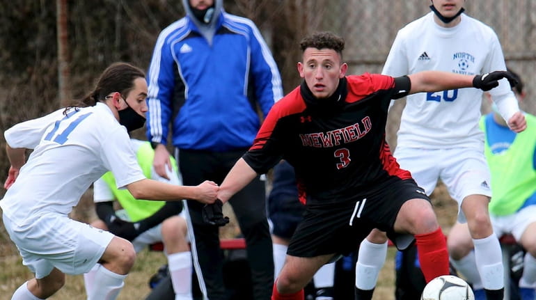 Newfield midfielder Lorenzo Selini (3) moves the ball past two...