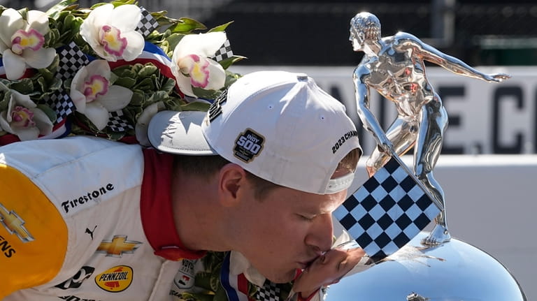 Josef Newgarden kisses the Borg-Warner Trophy during the traditional winners...