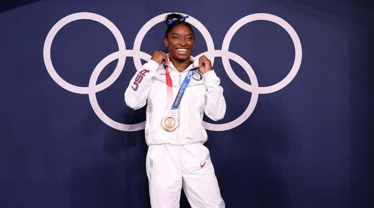 Simone Biles of Team USA poses with the bronze medal...