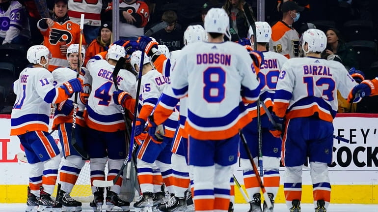 Islanders players celebrate after winning an NHL game against the Flyers...