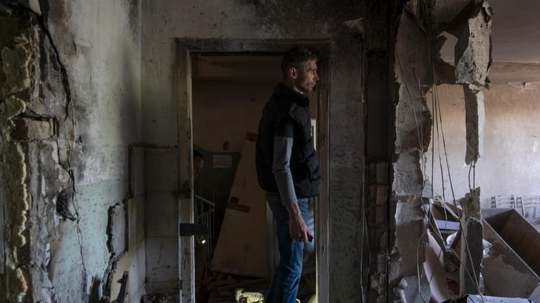 A man inspects his office damaged by a drone during...