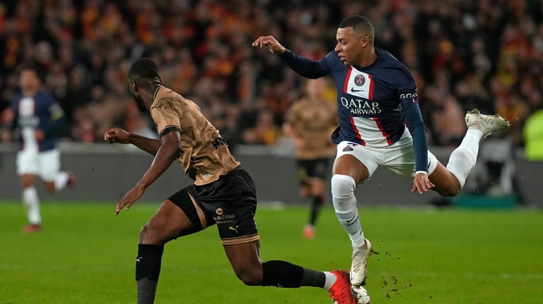 PSG's Kylian Mbappe, right, is challenged by Lens' Kevin Danso...