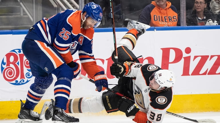 Anaheim Ducks' Derek Grant (38) is checked by Edmonton Oilers'...