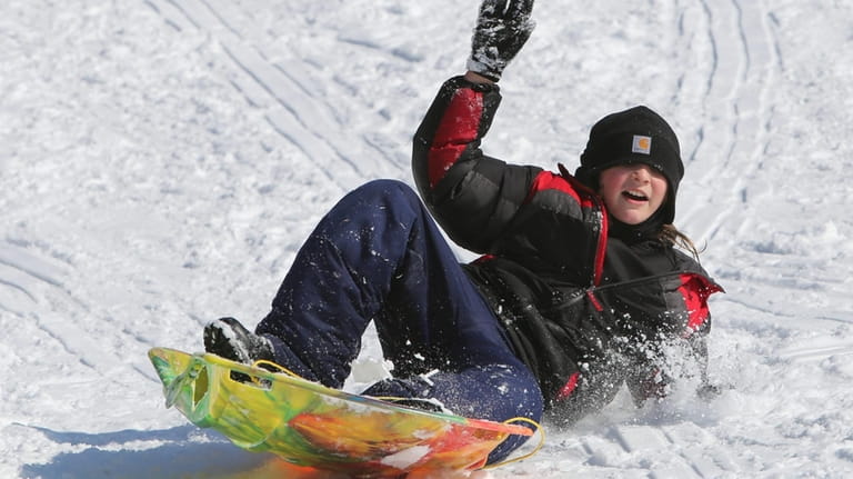 Michael Watson sledding down a hill at Hempstead Lake State...