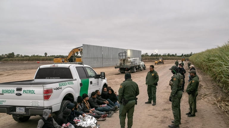 Border Patrol agents detain undocumented immigrants caught near a section...