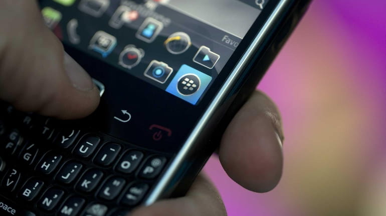 The BlackBerry qwerty keyboard, logo and icons are seen on...