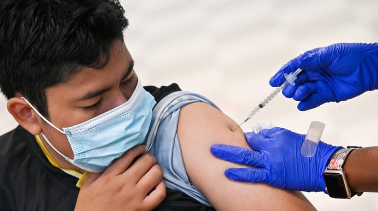Diego Mendez, 12, of Freeport, gets a COVID-19 shot at Freeport...