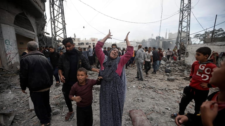 A Palestinian woman gestures following Israeli airstrikes in Khan Younis...