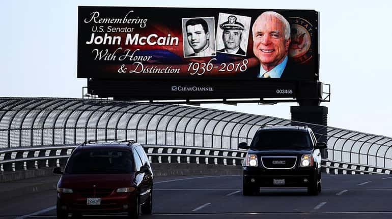 Sen. John McCain is remembered on a billboard along a...