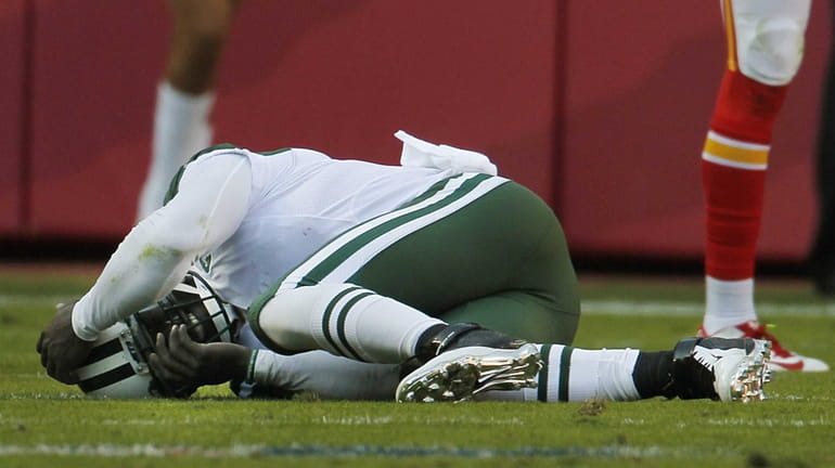 New York Jets quarterback Michael Vick (1) lies injured on...