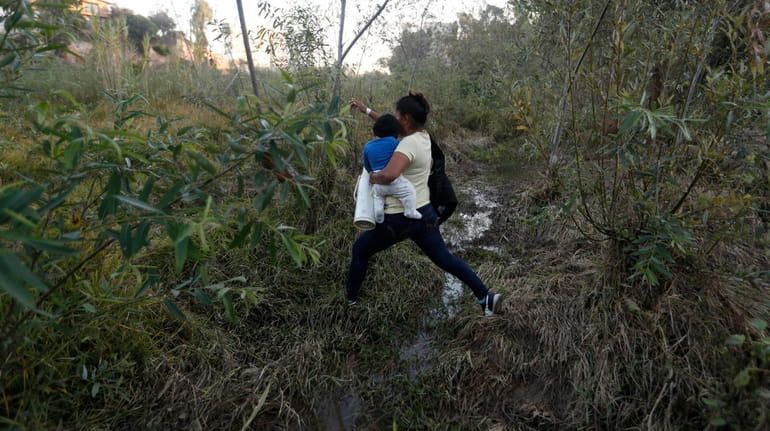 Yesenia Martinez, 24, carries her eight-month-old son Daniel as she...