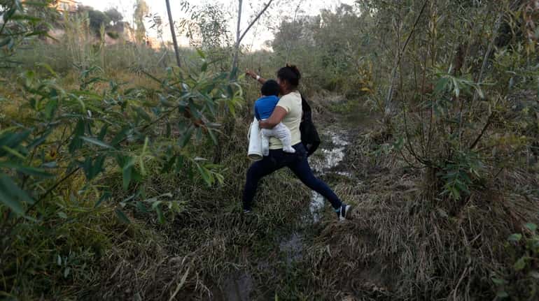 Yesenia Martinez, 24, carries her eight-month-old son Daniel as she...