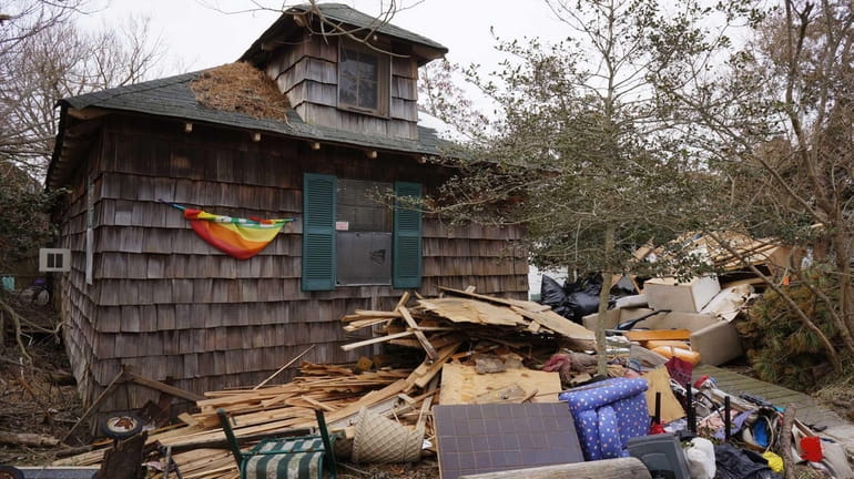 Debris from superstorm Sandy sits in front of a home...