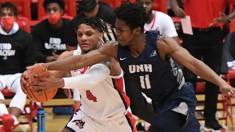 Stony Brook guard Tykei Greene is defended by New Hampshire...