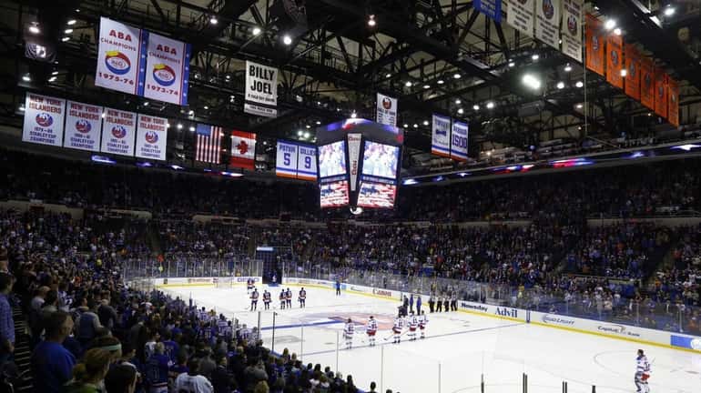 The New York Islanders and the New York Rangers stand...
