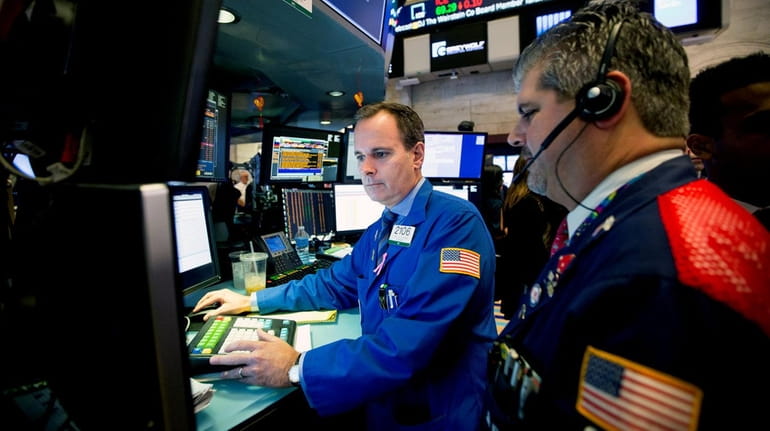 Traders work on the floor of the New York Stock...