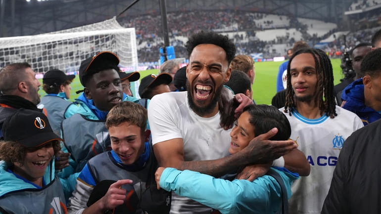 Marseille's Pierre-Emerick Aubameyang, centre, celebrates after winning a penalty shootout...