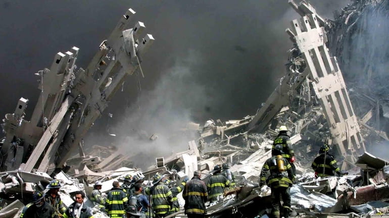Firefighters make their way through rubble after terrorists crashed two...
