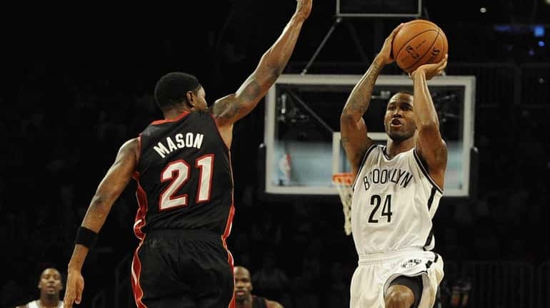 Nets' Chris Johnson attempts a shot past Miami Heat's Roger...